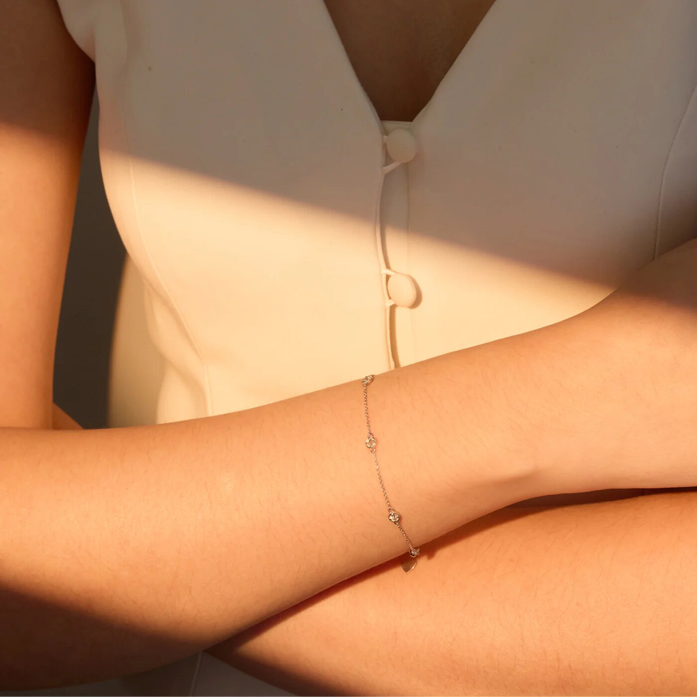 Close-up of a delicate bracelet with small gemstone accents on wrist, symbolizing protection, grounding, and balanced energy